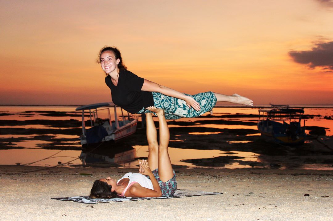 santosha yoga teacher training students on beach yoga at sunset bali